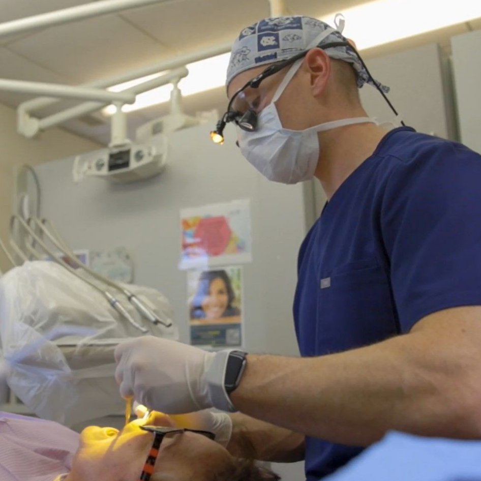 A dentist is examining a patient 's teeth in a dental office near Knightdale, NC.