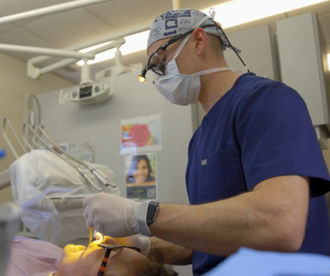 A dentist is examining a patient 's teeth in a dental office near Garner, NC.