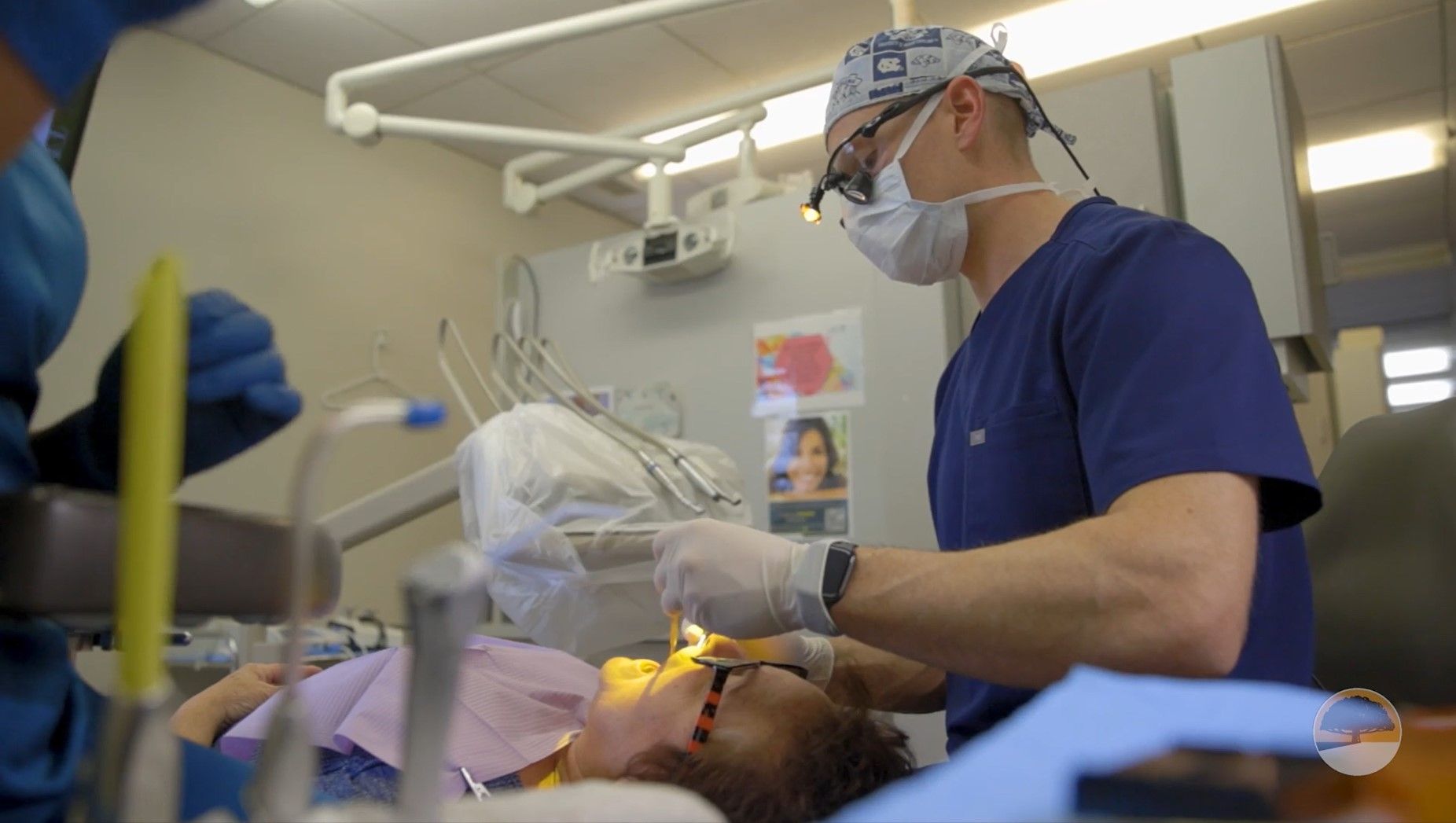 A dentist is examining a patient 's teeth in a dental office.