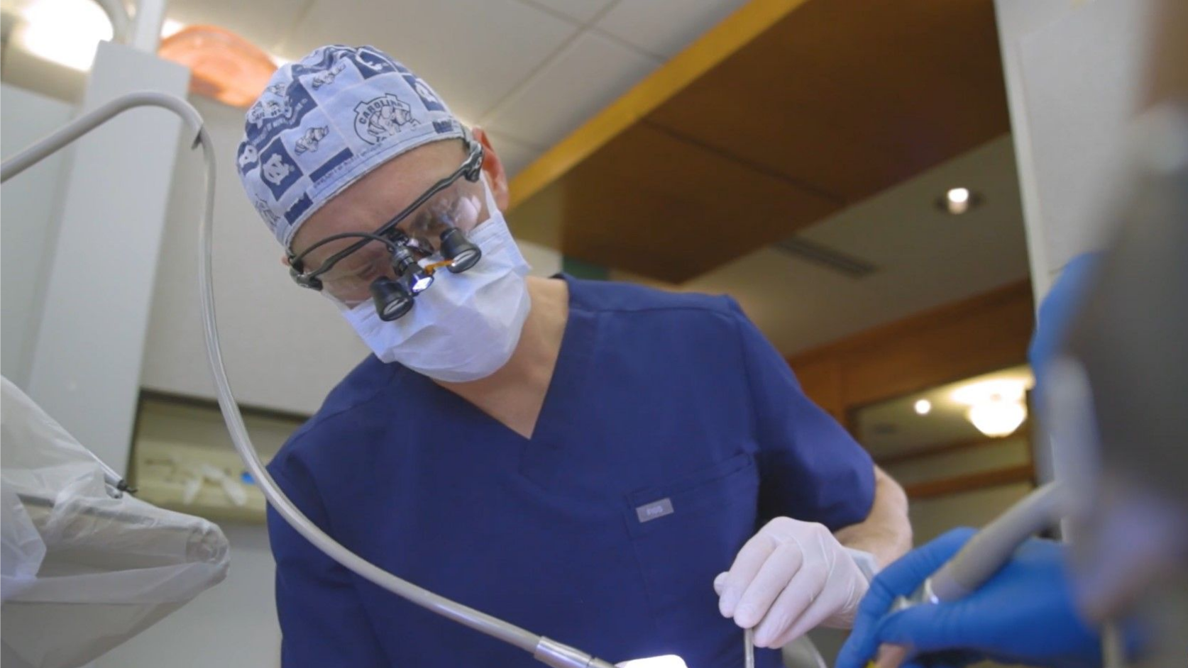 A dentist is working on a patient 's teeth in a dental office.