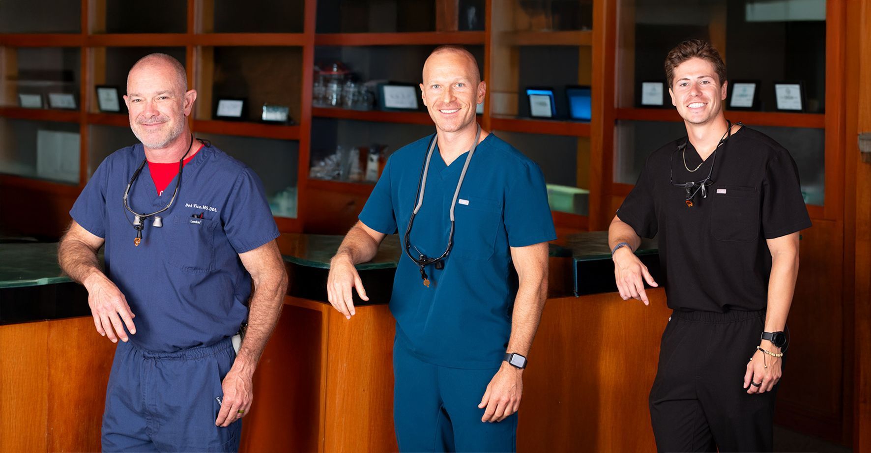 Three men in scrubs are standing next to each other
