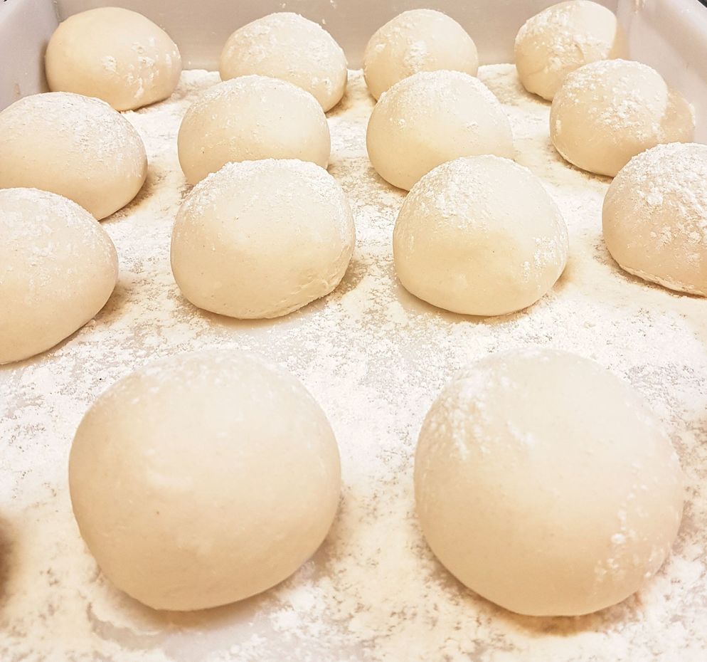 Pile di focacce sottili appoggiate su un vassoio di metallo in una cucina.