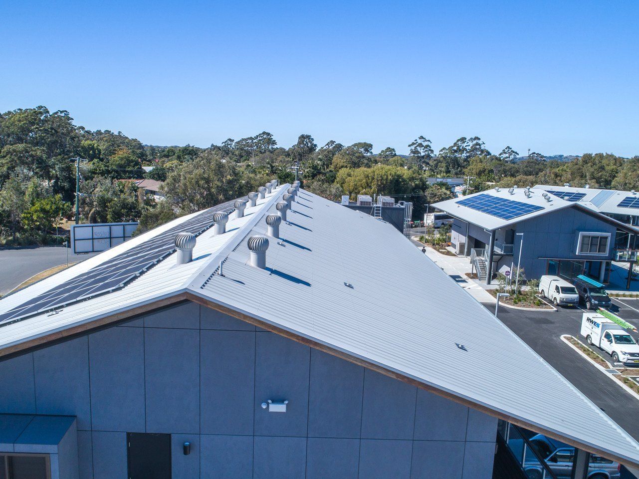 An Aerial View of a Building With Solar Panels on the Roof — Coastal Roofing Professionals In Chinderah, NSW