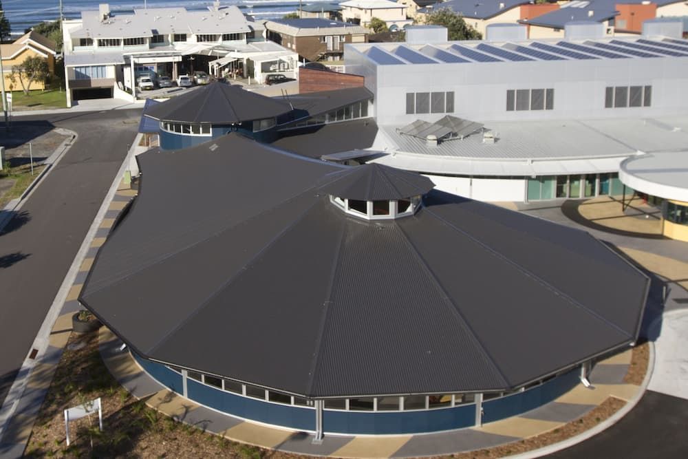 An Aerial View of a Building With a Round Roof — Coastal Roofing Professionals In Chinderah, NSW