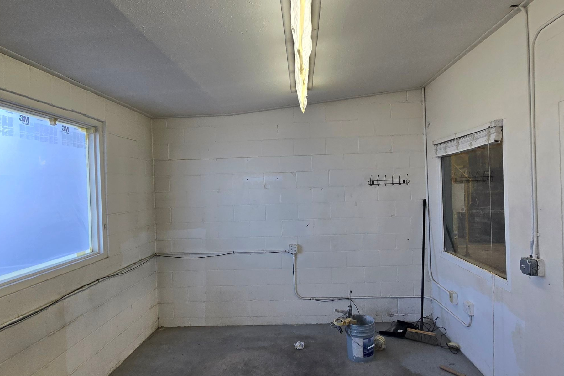 An empty room with white brick walls and a window
