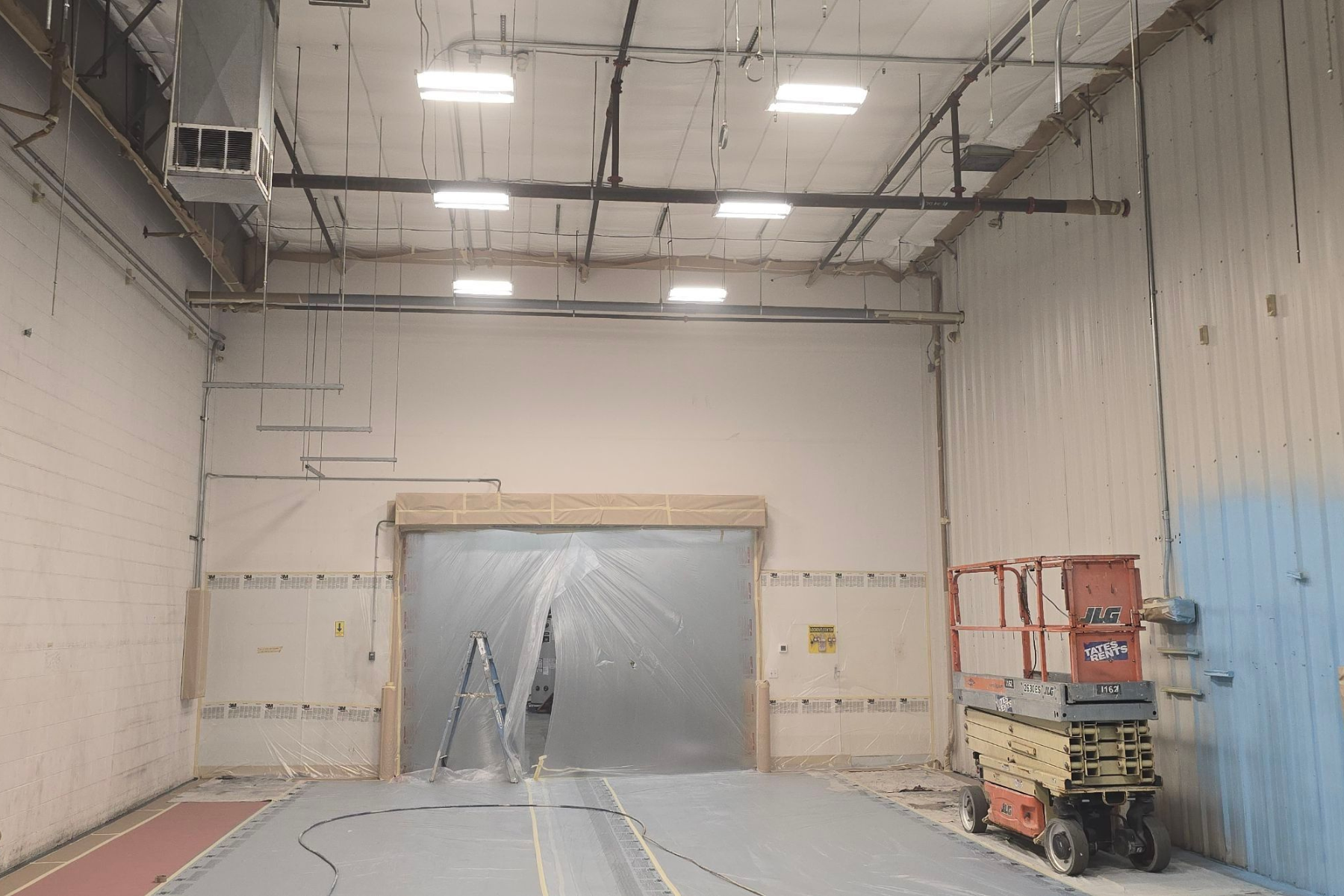 A warehouse with a ladder and a lift in it