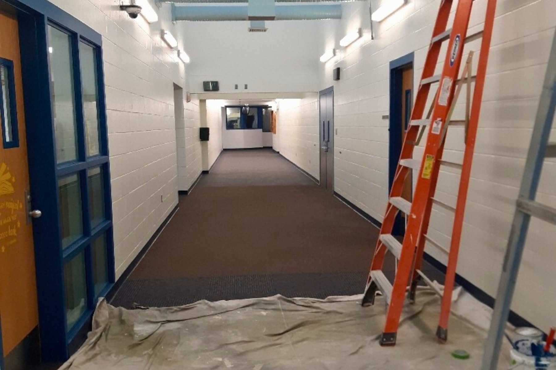 A long hallway with a ladder in the middle of it