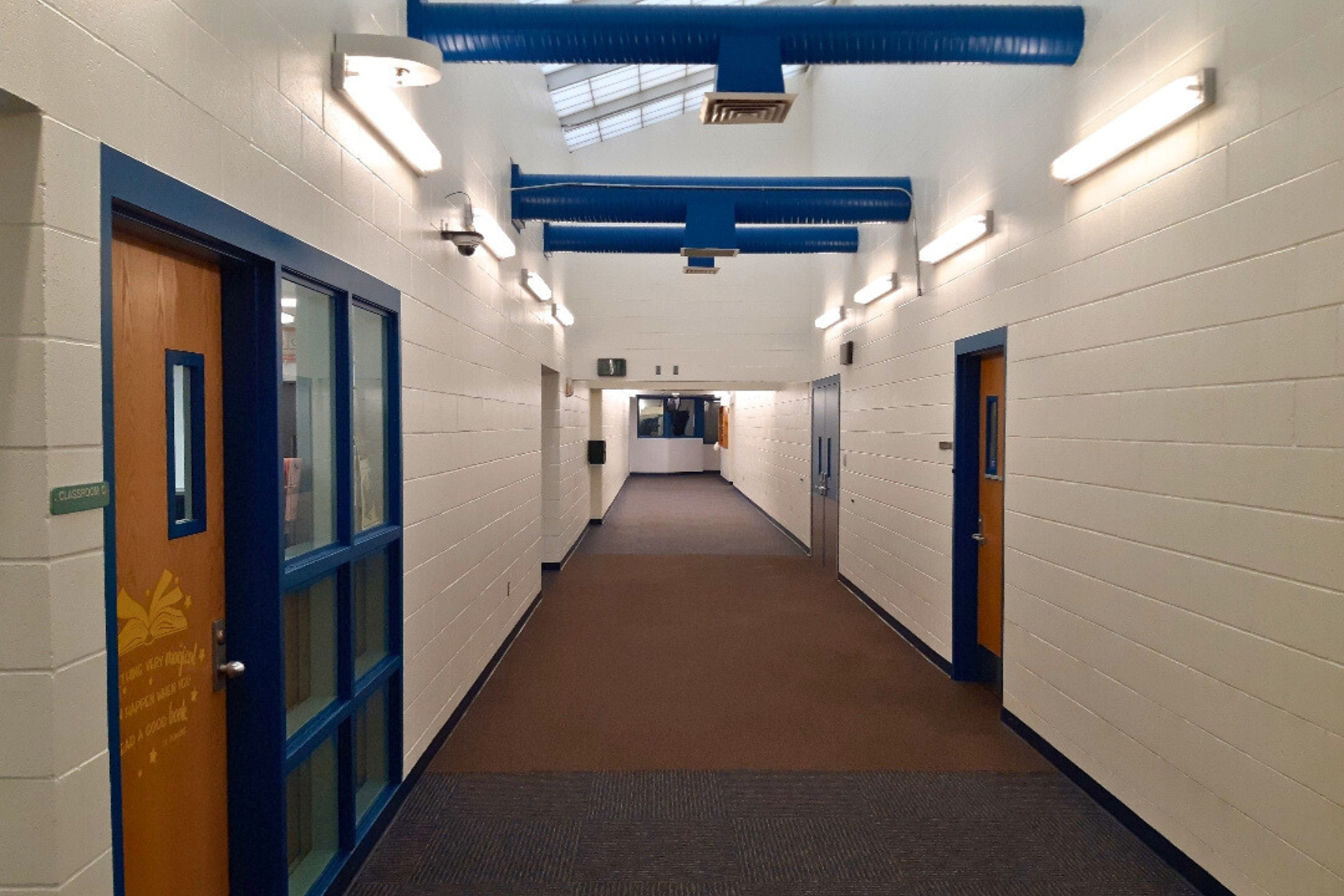 A long hallway in a building with a few doors