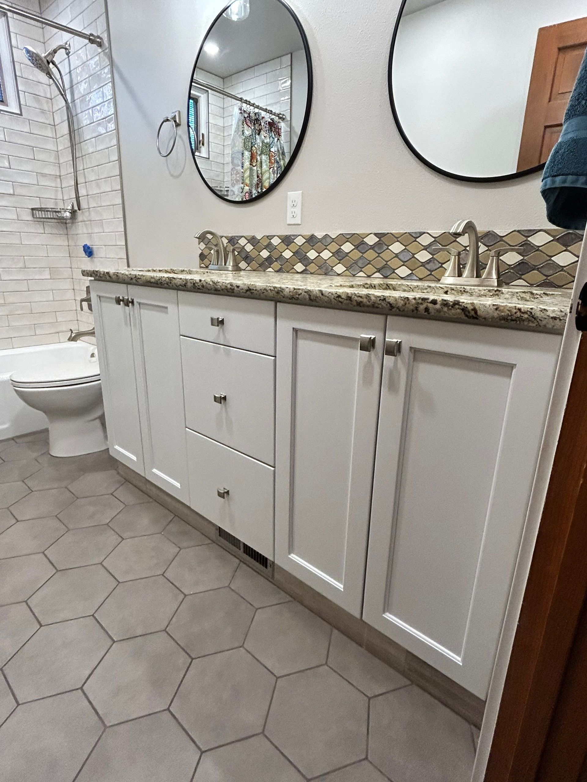 A bathroom with two sinks , a toilet , and a bathtub.