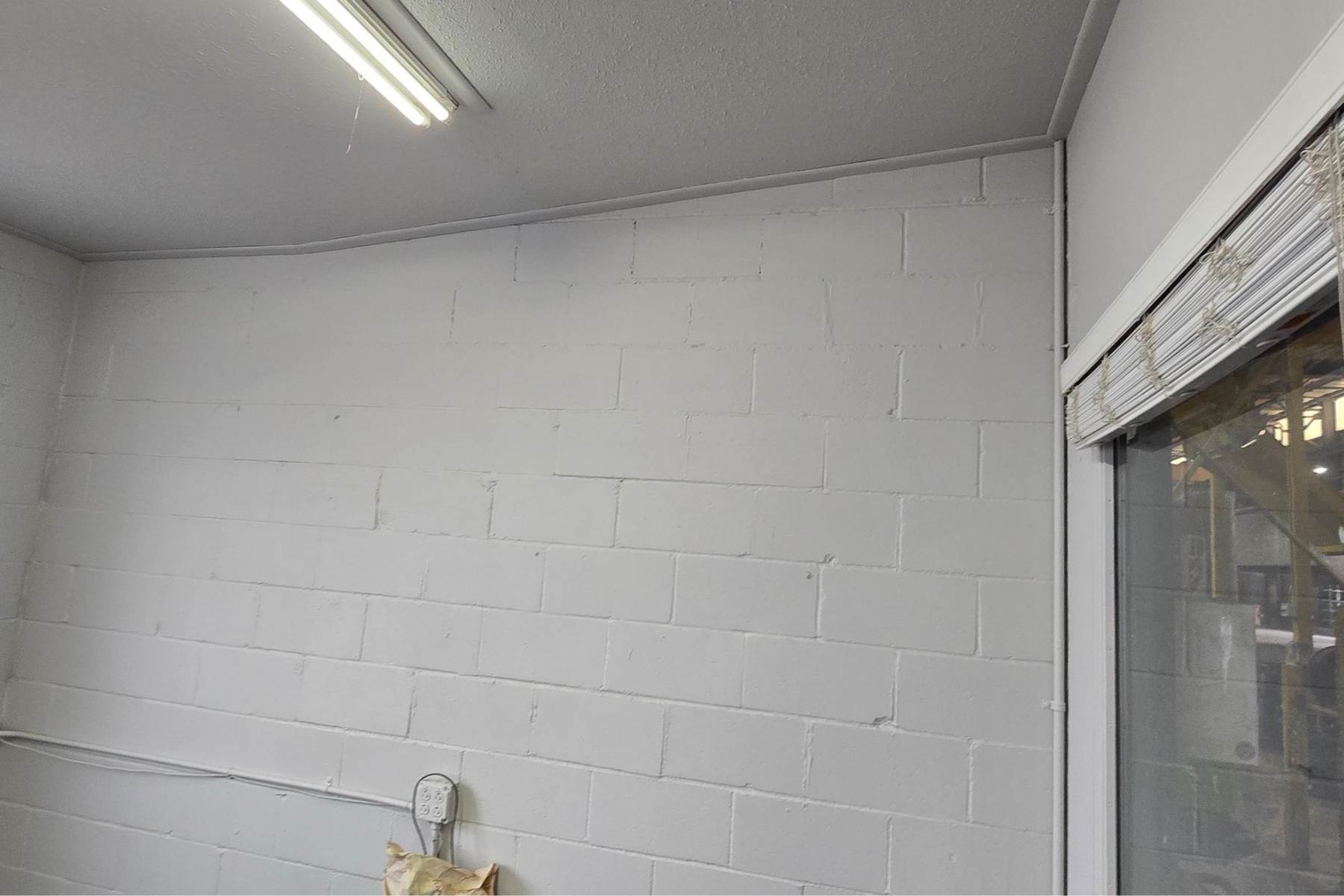 A room with white brick walls and a glass door.