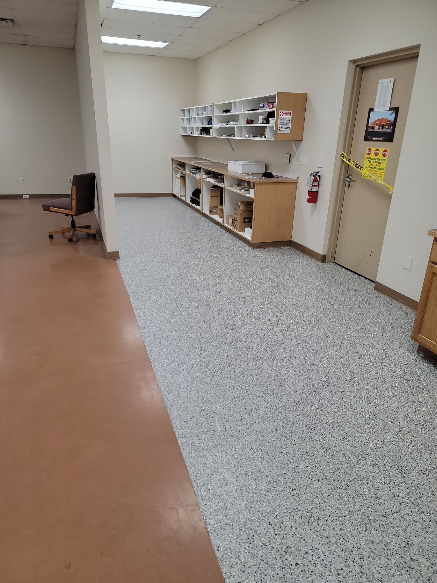 A long hallway with a concrete floor and cabinets.