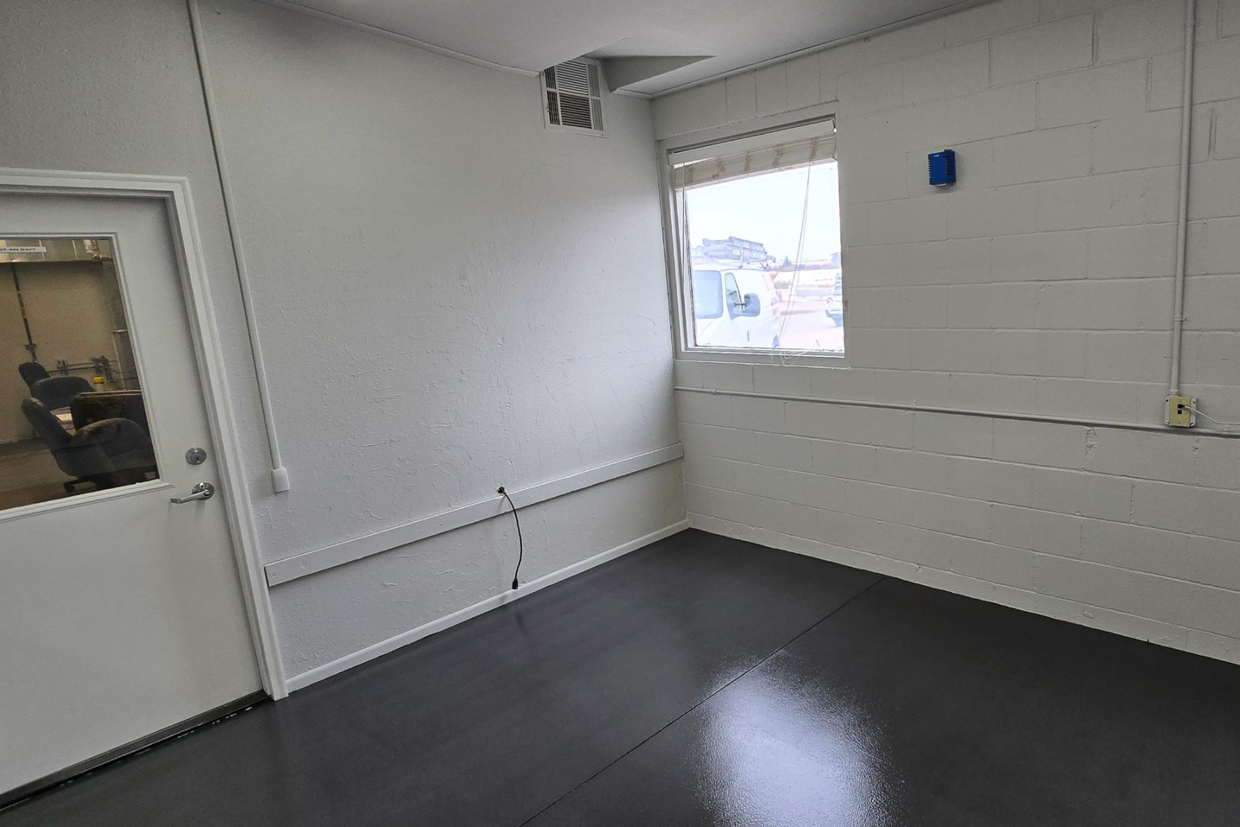 An empty room with a window and a door.