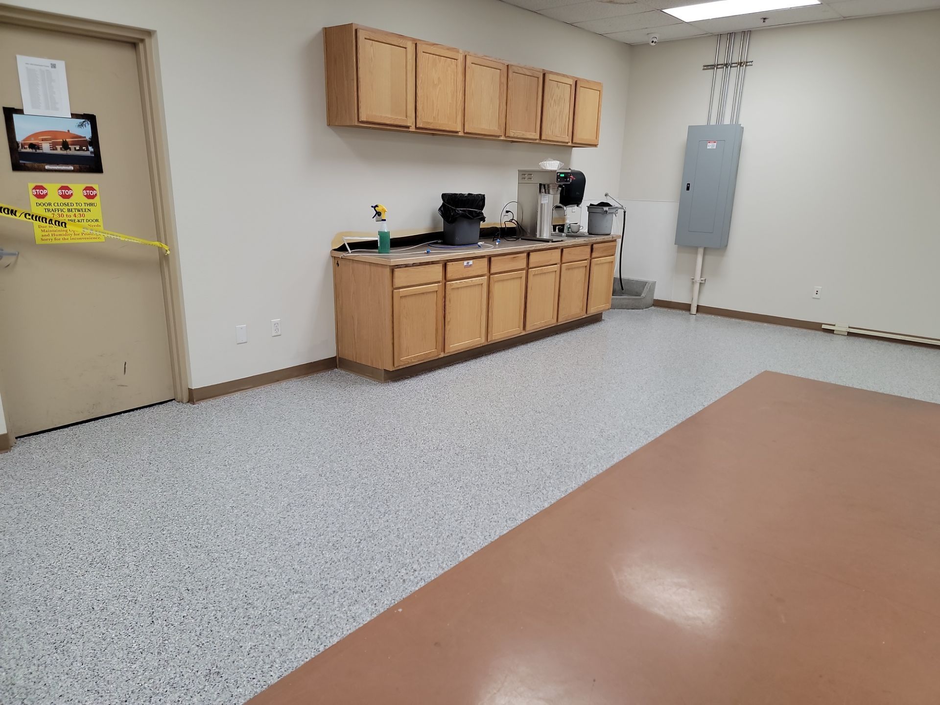 A kitchen with wooden cabinets and a coffee maker on the counter.