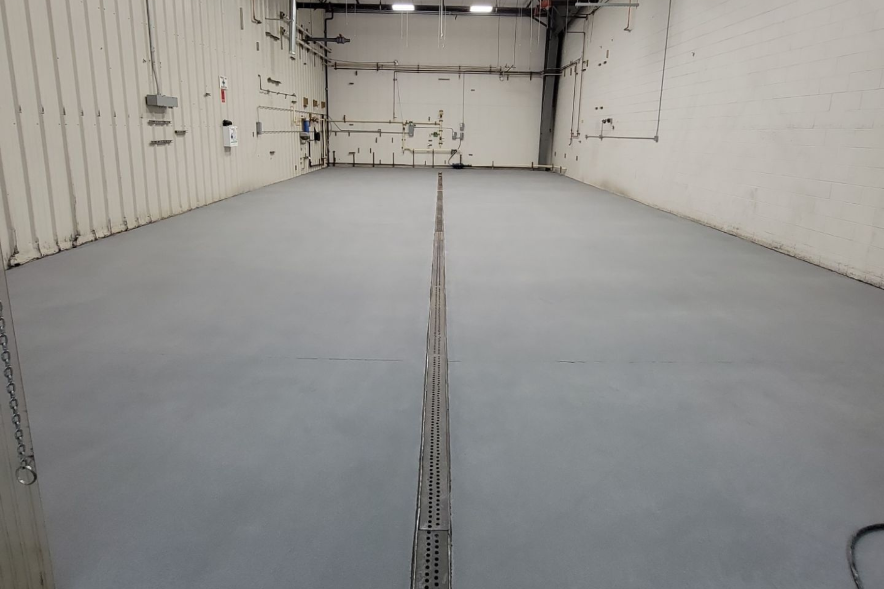 A large empty room with a gray floor and white walls.