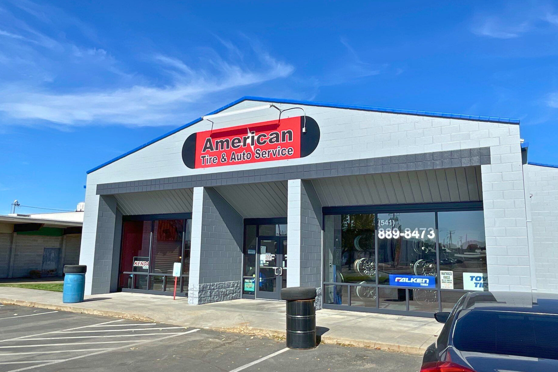 A store front with a car parked in front of it.