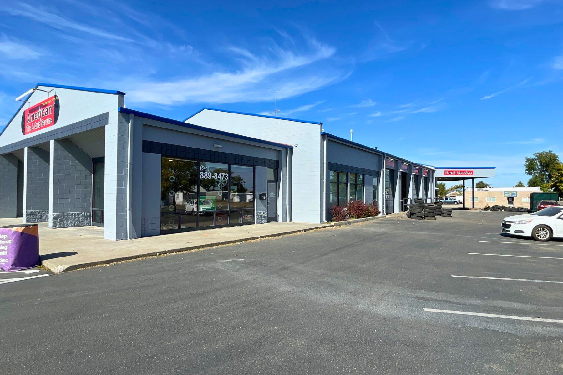 A large building with a lot of windows and cars parked in front of it.