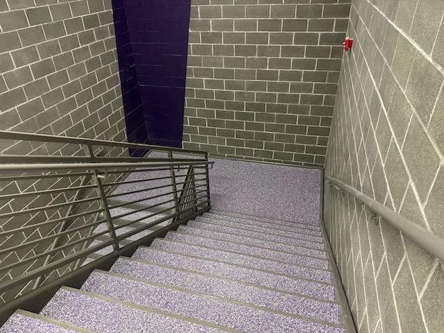 A set of stairs leading up to a brick wall.