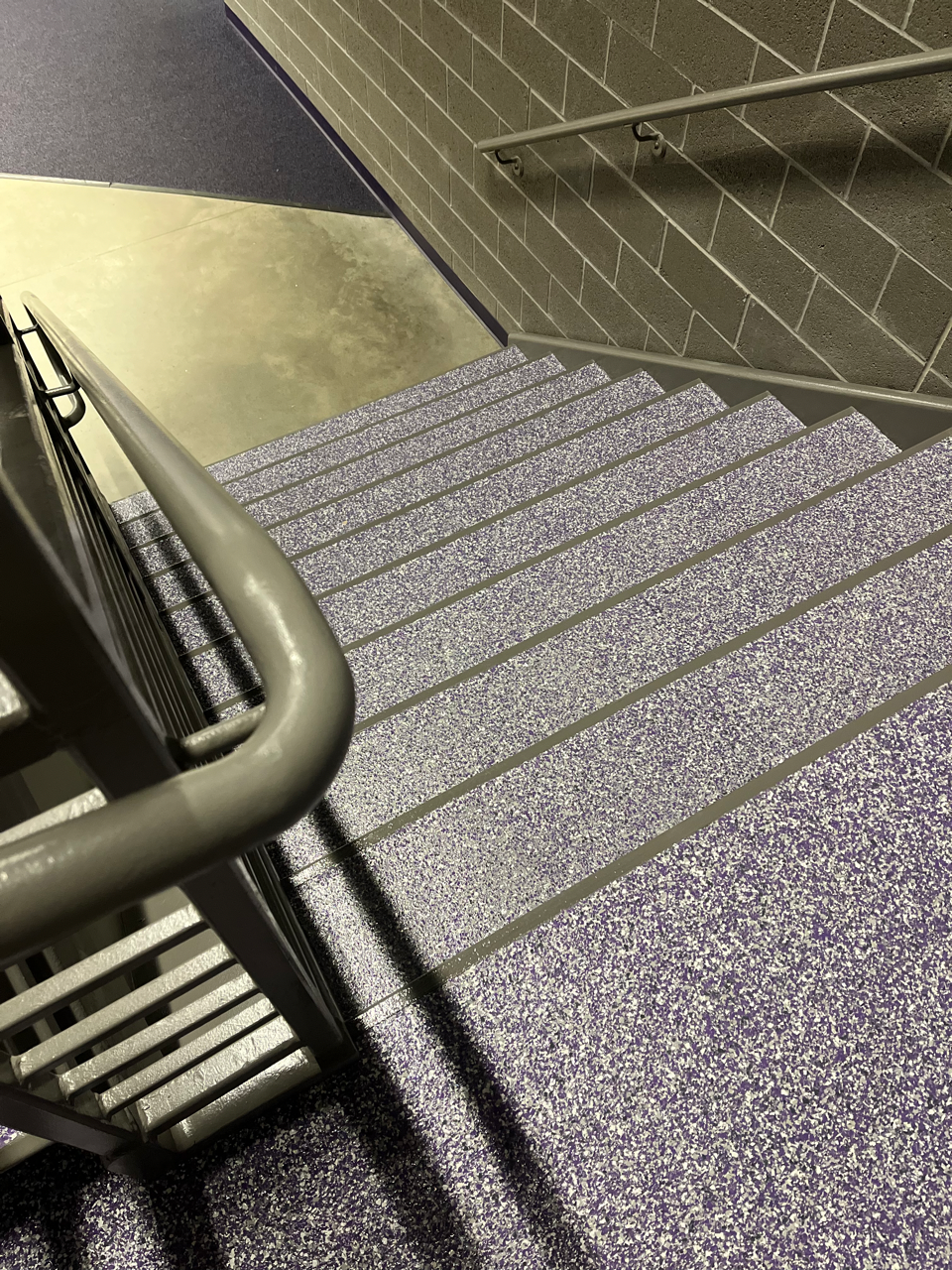 A set of purple stairs with a gray railing