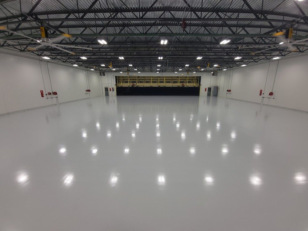 A large empty warehouse with a lot of lights on the floor.