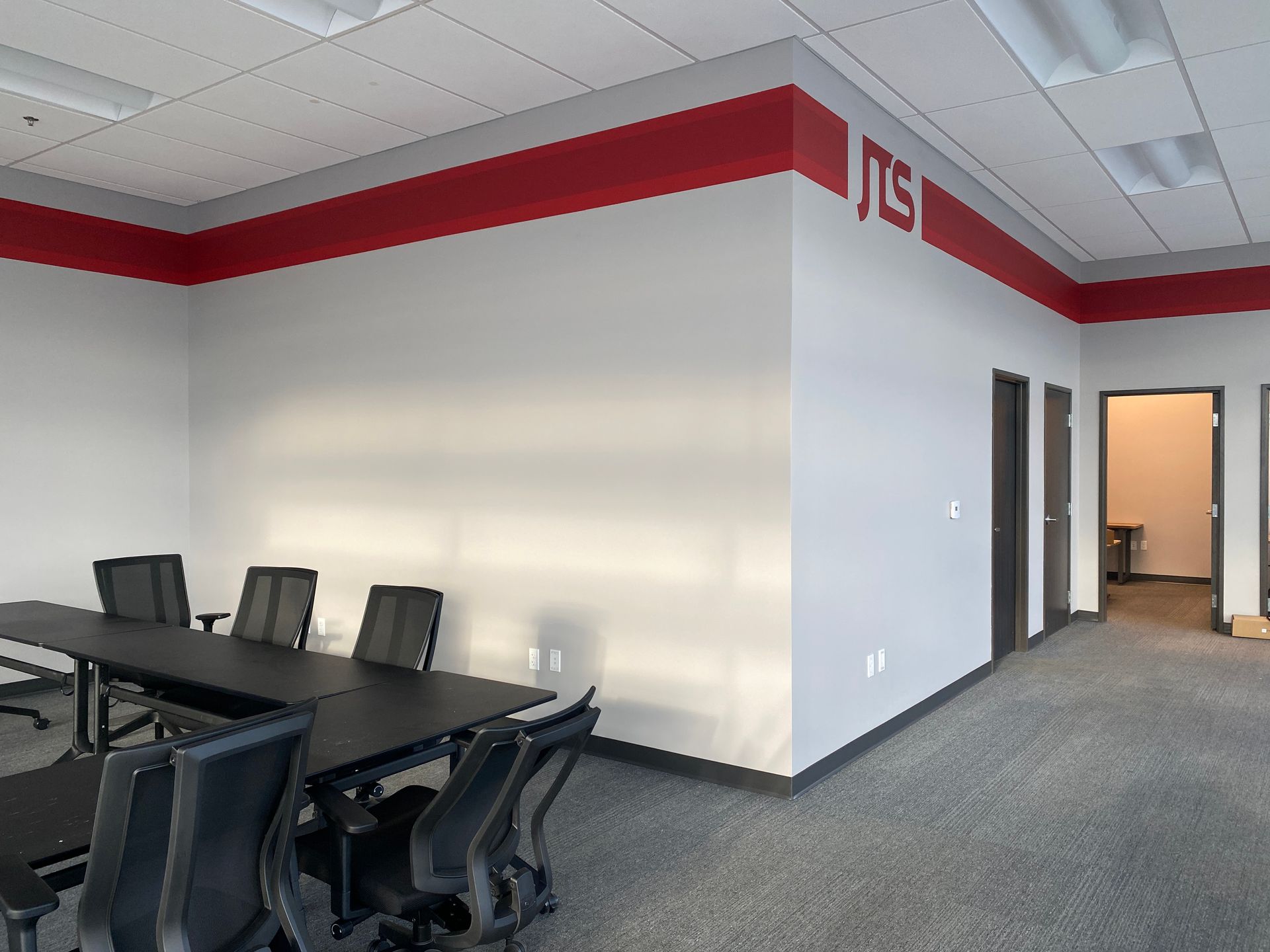 A conference room with a jts logo on the wall