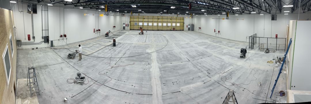 A large empty warehouse with a runway in the middle of it.
