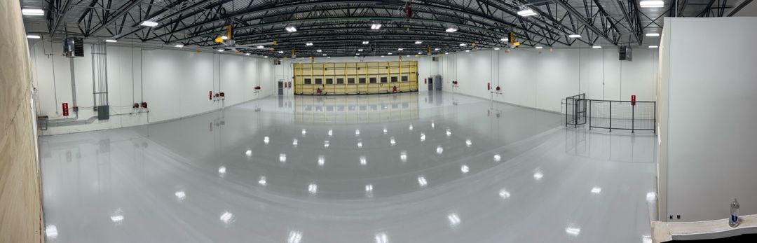 A large empty warehouse with a lot of lights on the floor.