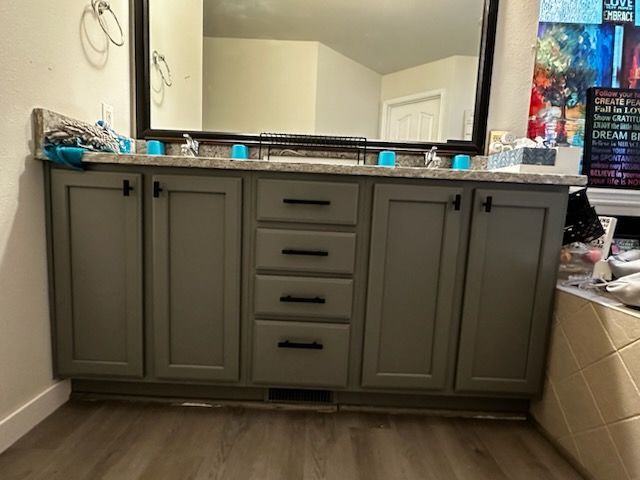 A bathroom vanity with two sinks and a large mirror.