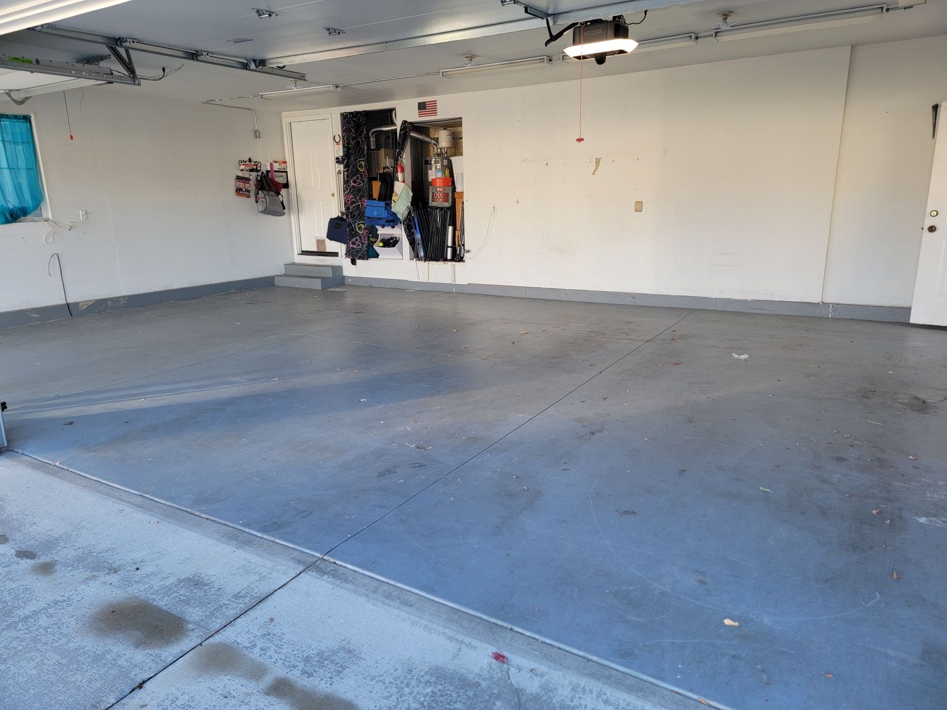 An empty garage with a gray floor and white walls