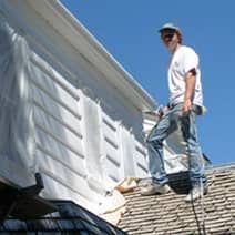 A man is standing on top of a roof.