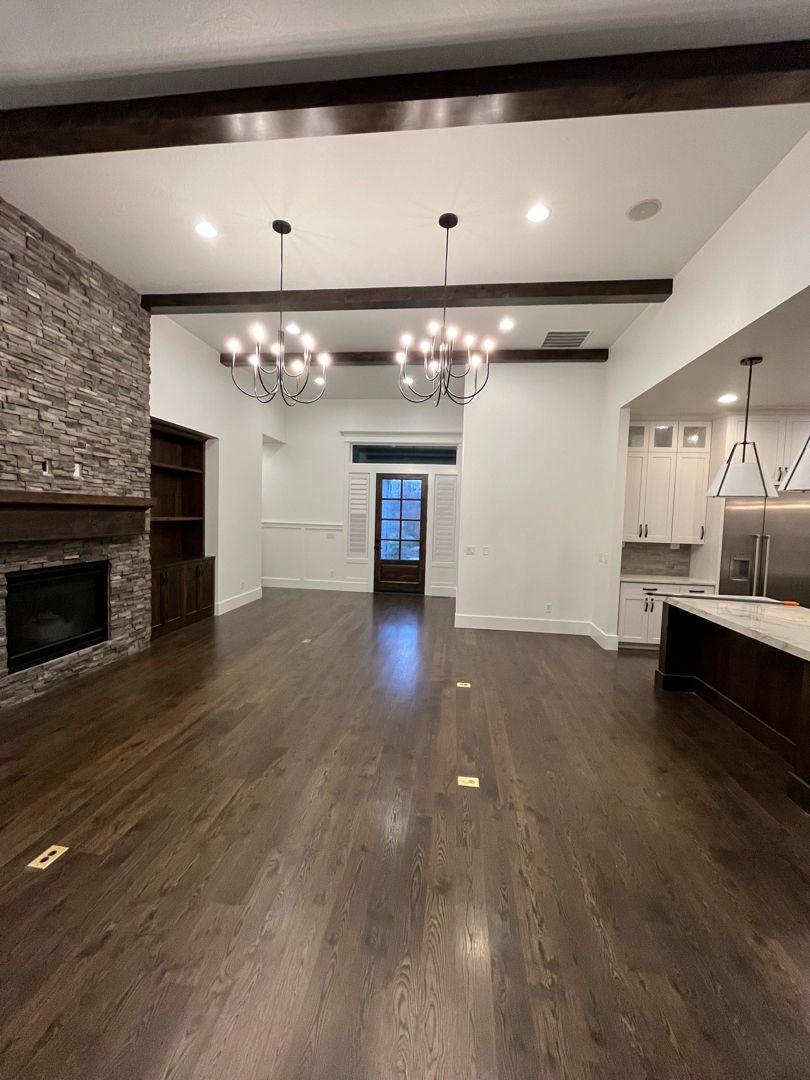 A large empty room with hardwood floors and a fireplace.