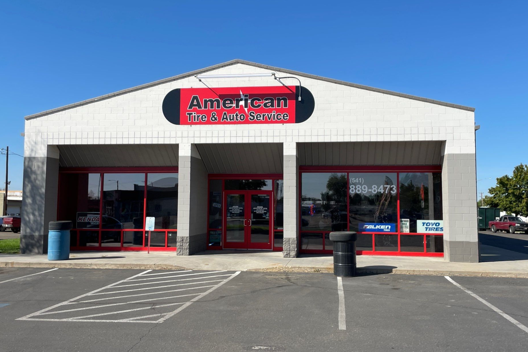 A white building with a red sign that says american