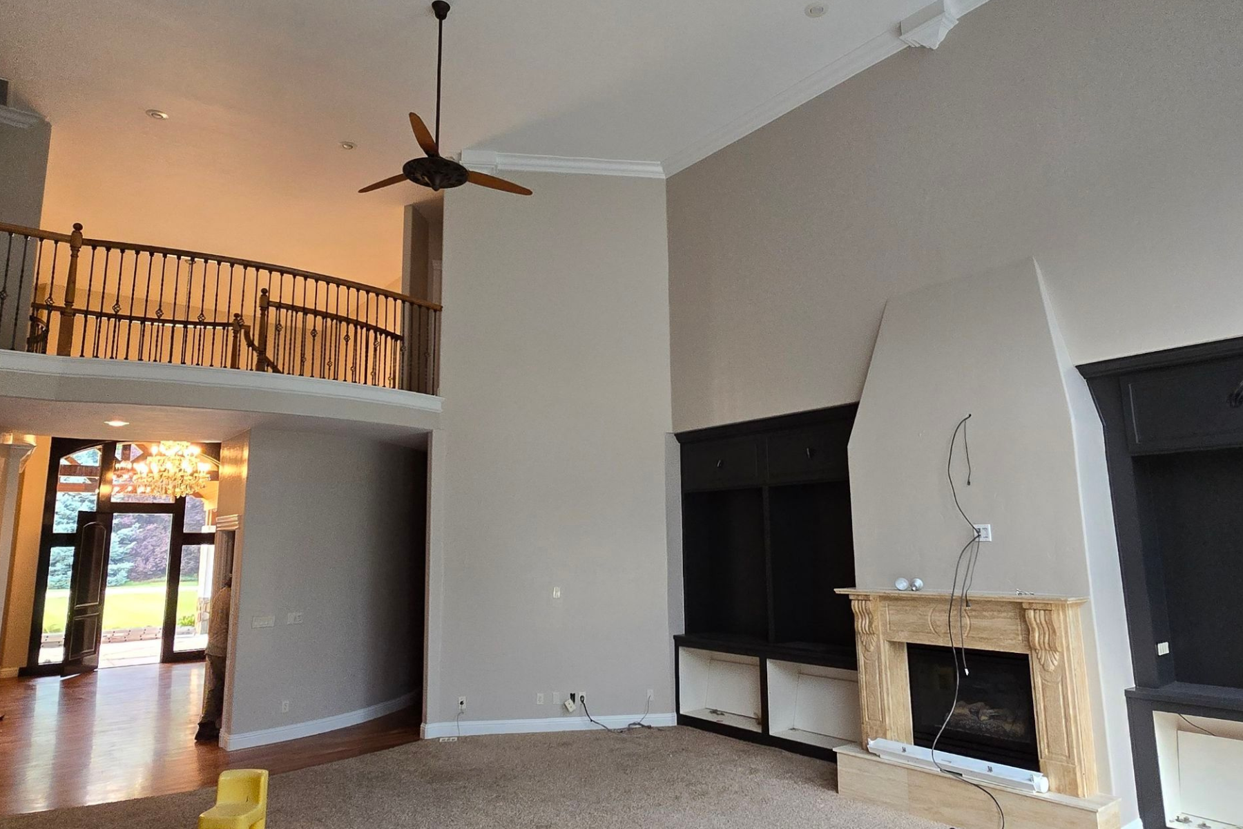 A living room with a fireplace and a ceiling fan.