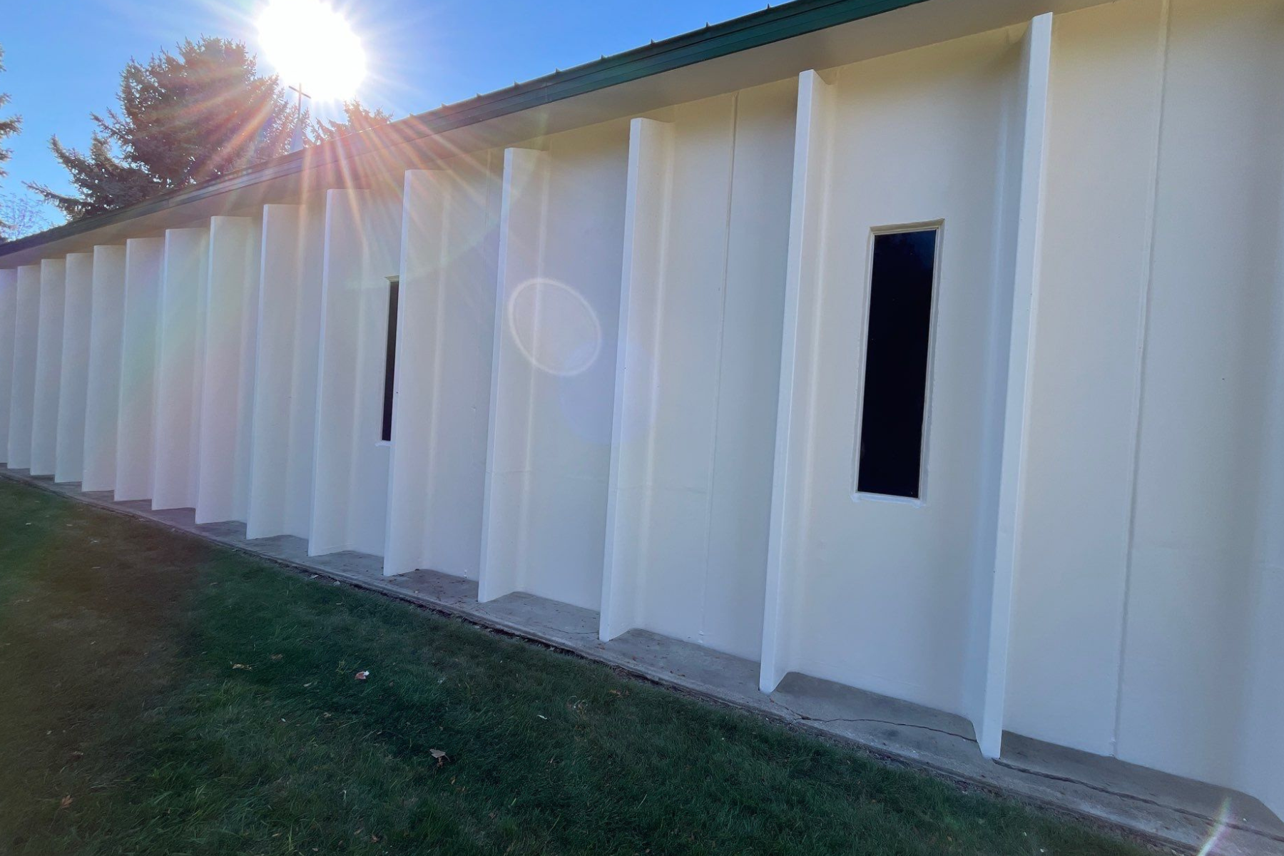 The sun is shining through the windows of a white building.