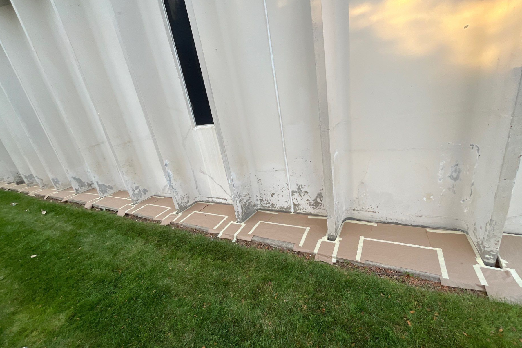 A white wall is sitting on top of a lush green lawn.