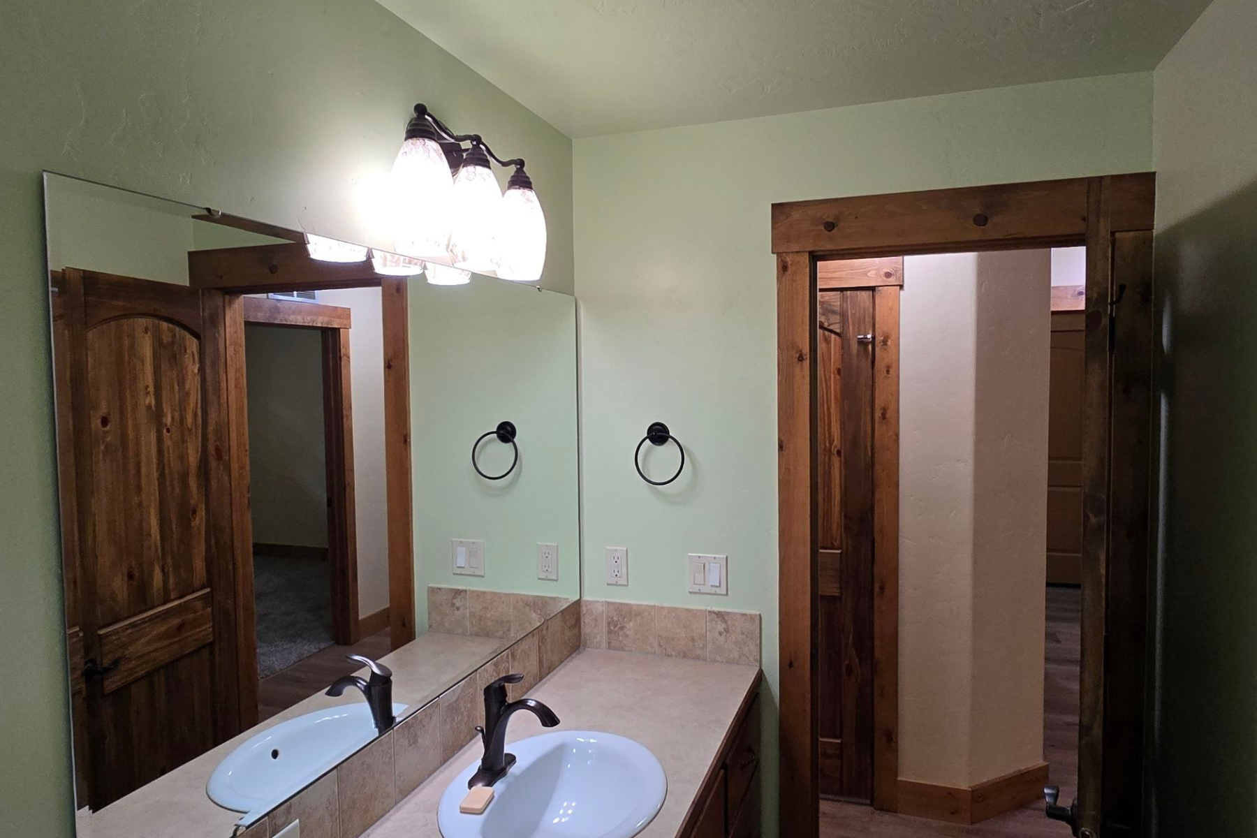 A bathroom with two sinks and a large mirror.