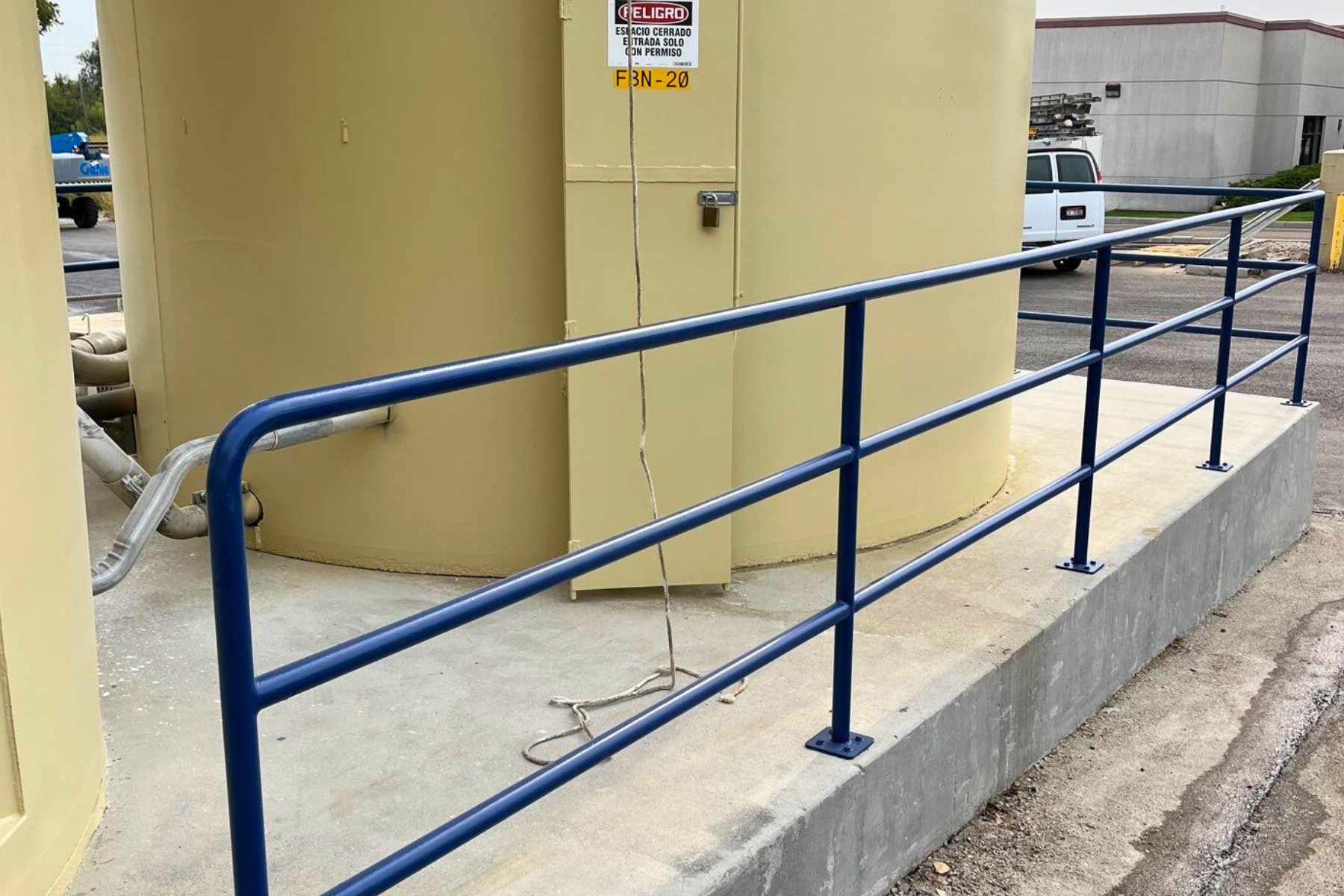 A blue railing with a warning sign on it