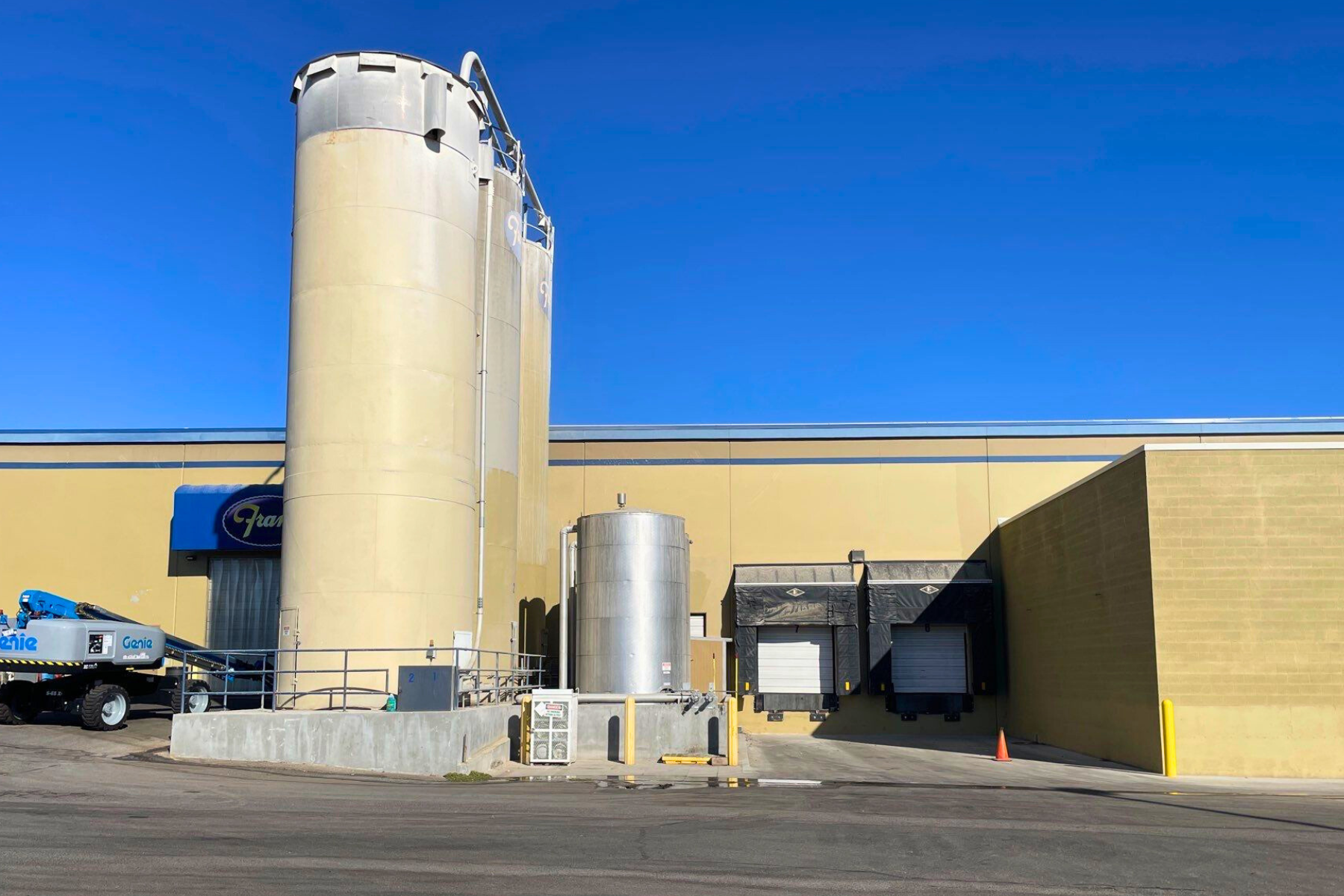 A large building with a lot of silos in front of it.