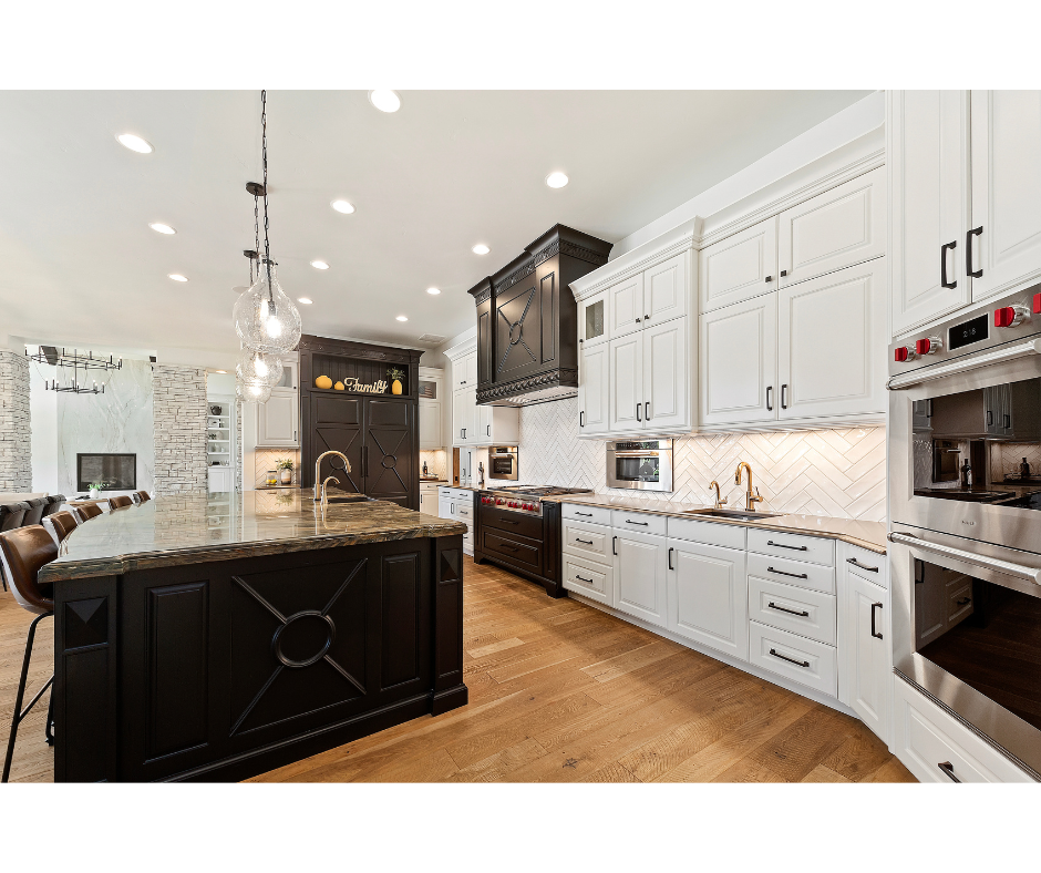 A kitchen with white cabinets , black cabinets , stainless steel appliances and a large island.