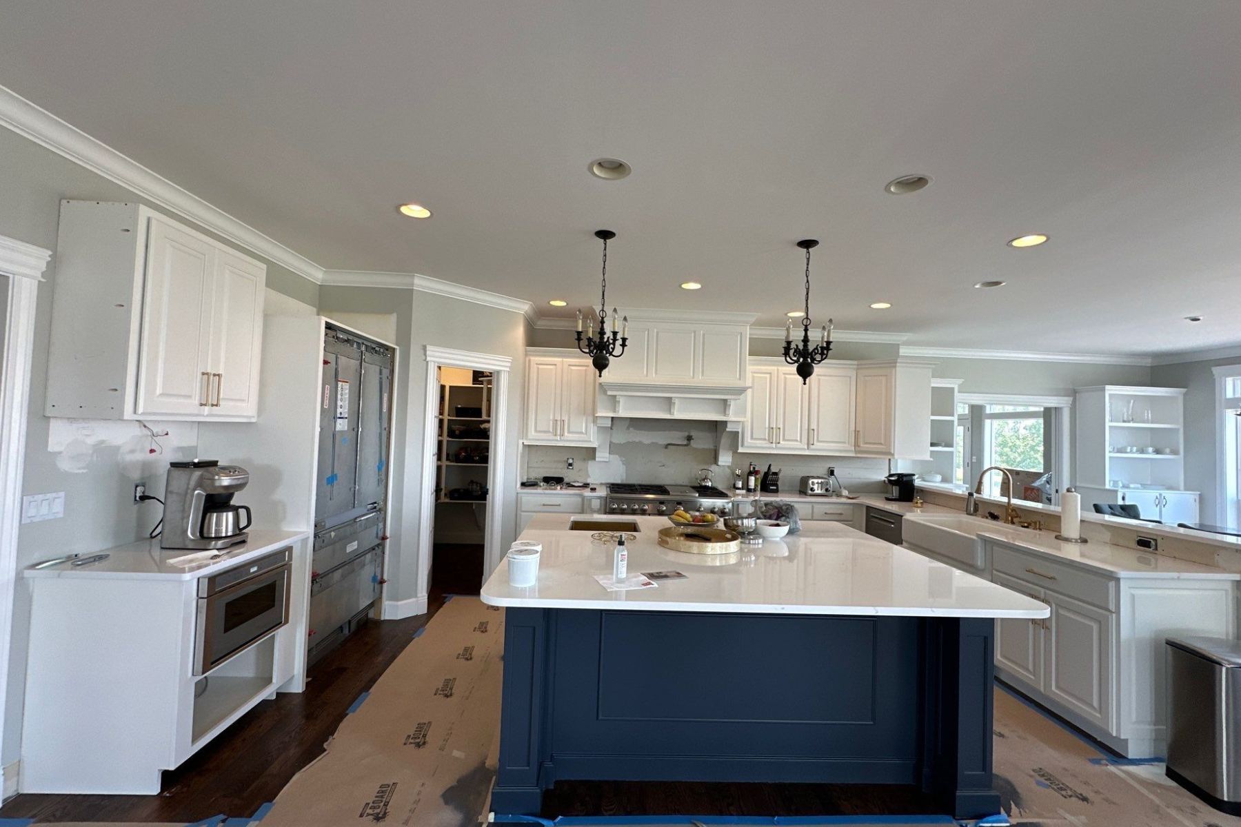 A kitchen with white cabinets and a large island in the middle.