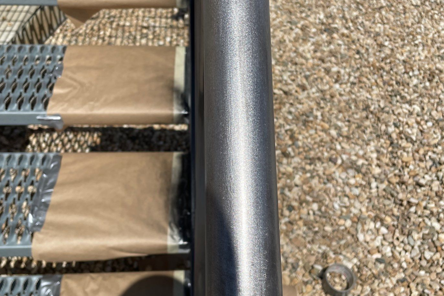 A metal pole is sitting on top of a pile of gravel.