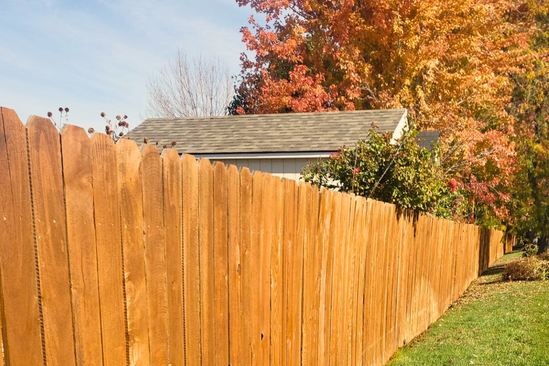 A wooden fence with a house in the background