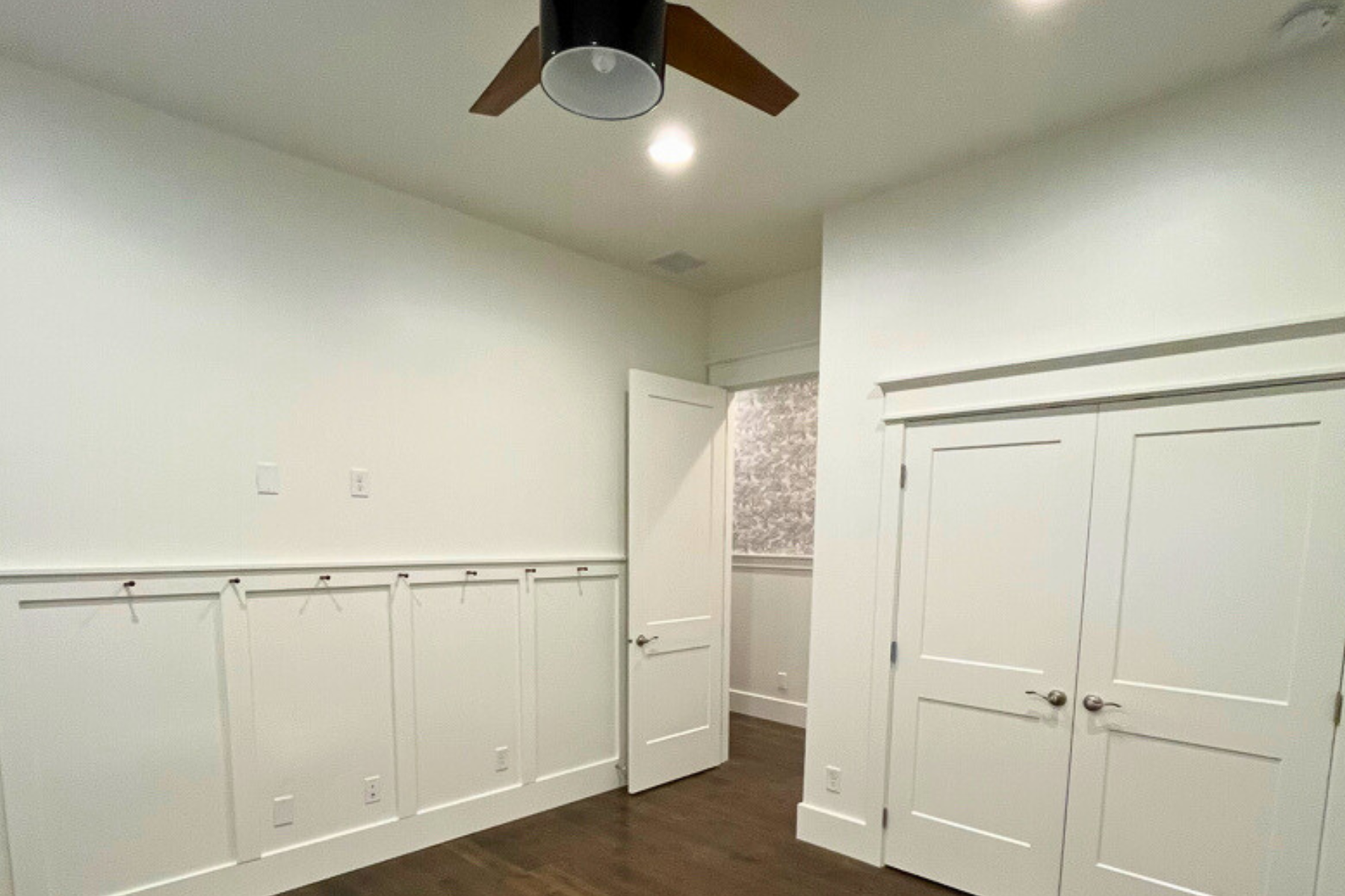 There is a ceiling fan in the corner of the room.