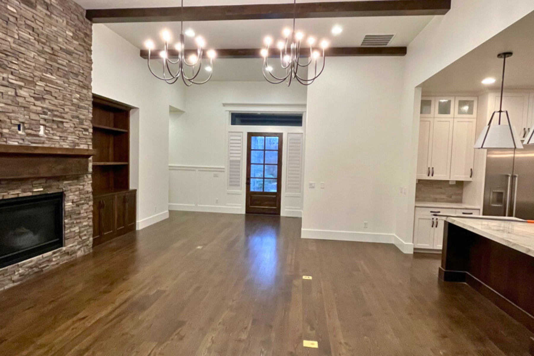 An empty living room with hardwood floors and a fireplace.