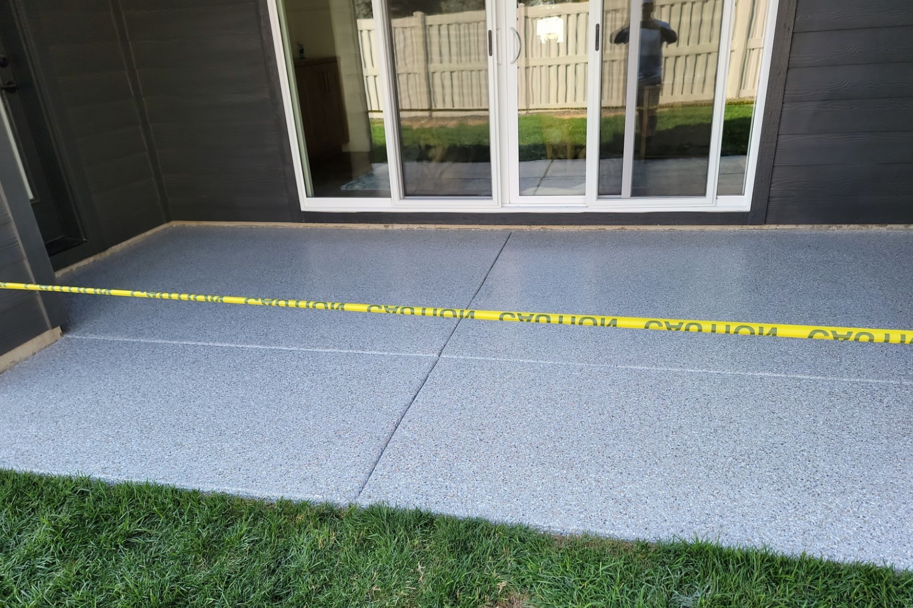 A concrete patio with a yellow caution tape around it.