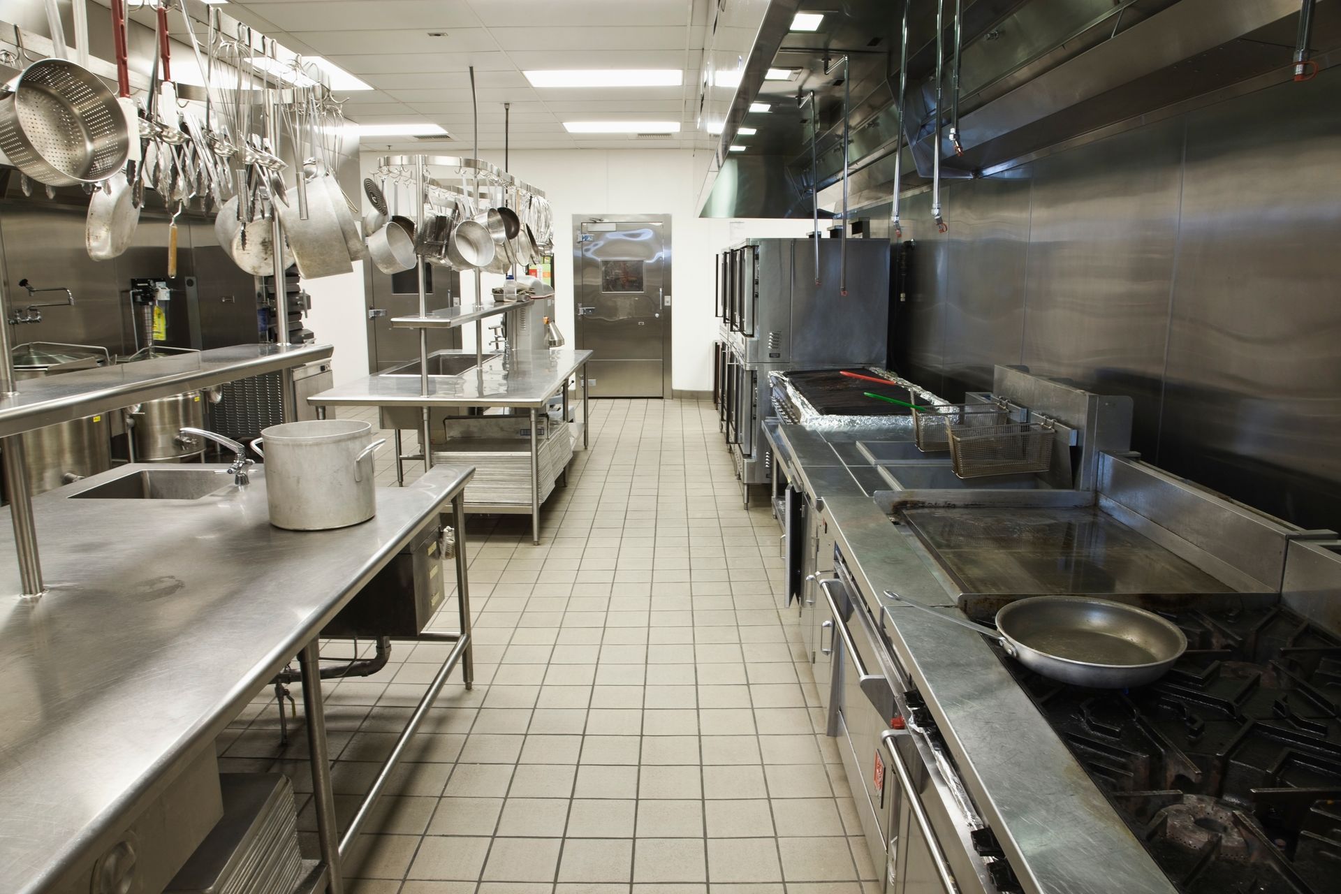 Commercial kitchen with stainless steel appliances and countertops.