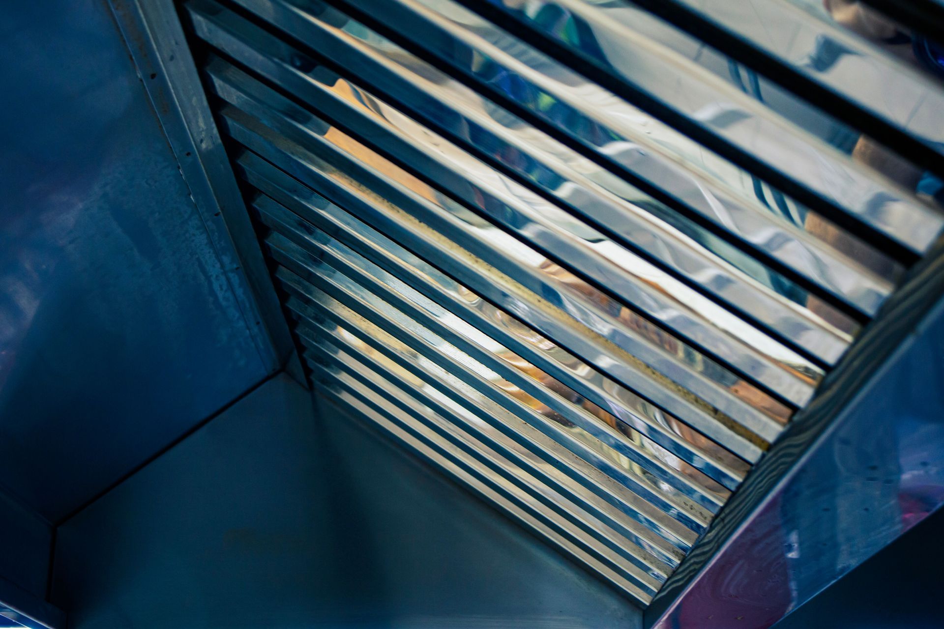 Commercial kitchen hood totally cleaned, grease trap stainless steel close-up.