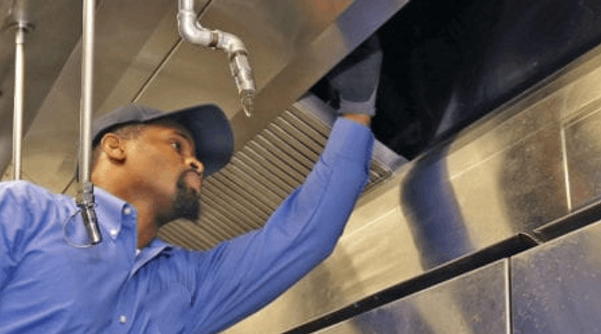 A man in a blue shirt is working on a pipe A man in a blue shirt is working on a pipe