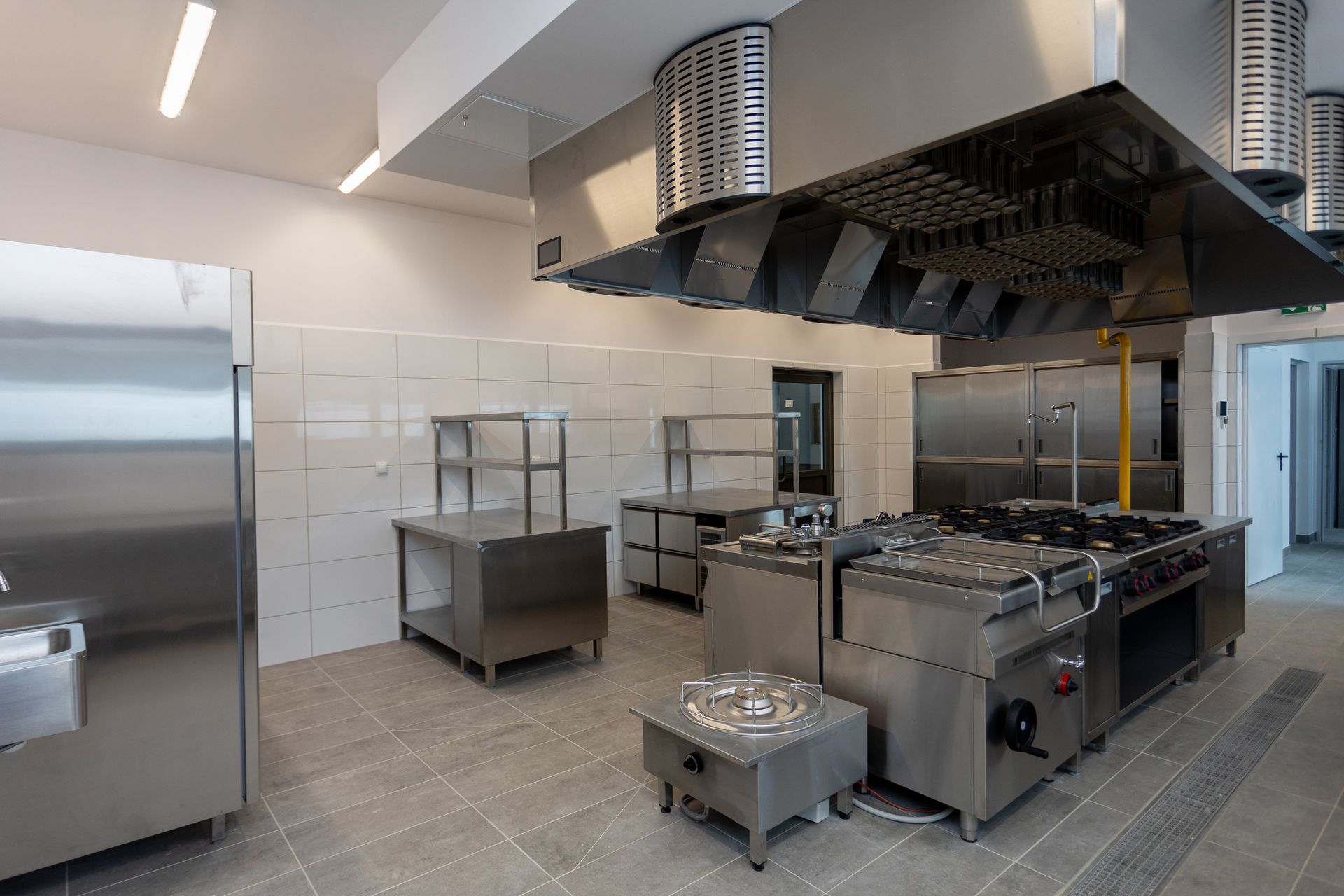 A modern industrial kitchen equipped with high-quality stainless steel equipment and appliances.