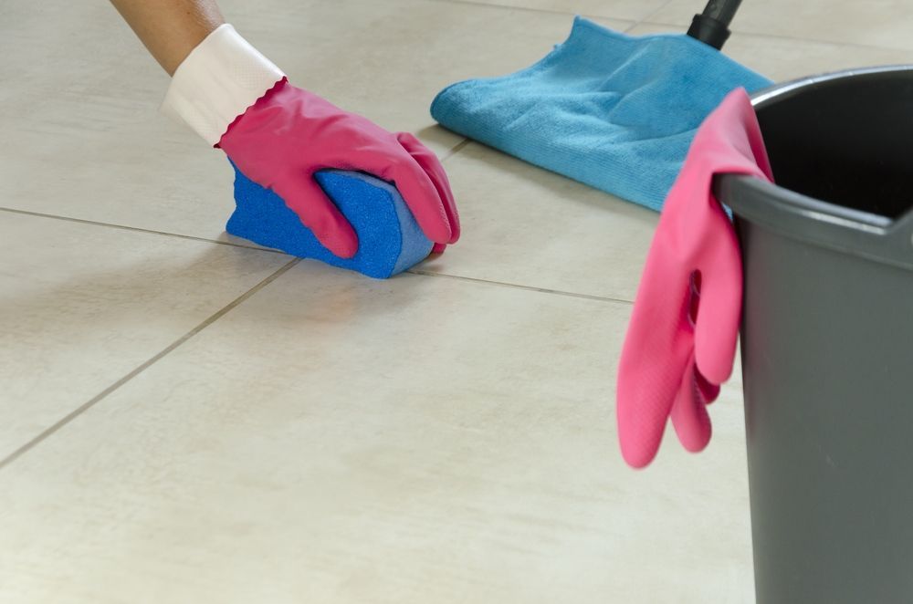 Person Cleaning Tile Floor With Sponge, Mop, Pink Gloves, And Bucket — David Son Tiling in Springdale Heights, NSW