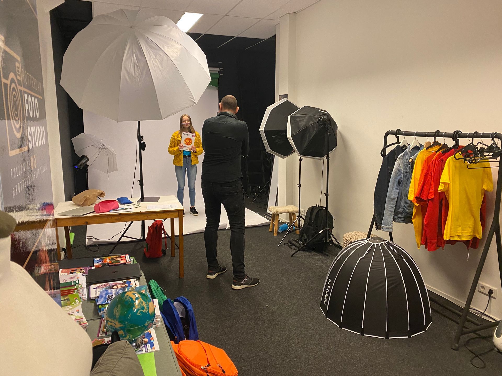 Een man maakt een foto van een vrouw in een fotostudio.